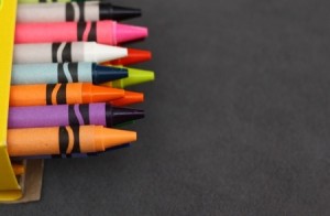 multicoloured wax crayons poking out of a box