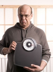 unhappy man looking at is weight