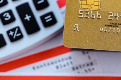 a gold credit card, bank statement and calculator