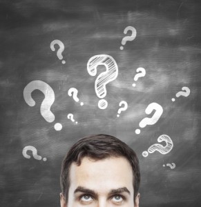 man with questions symbol on blackboard