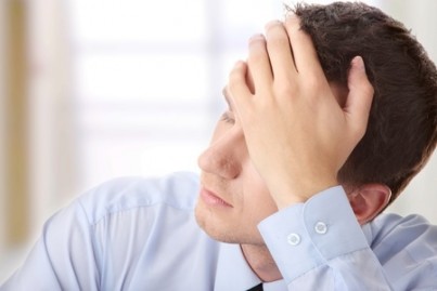 Businessman in depression with hand on forehead
