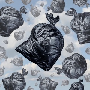 Garbage concept as black trash bags with an unpleasant smell falling from the sky as a background of environmental damage issues and waste management problems