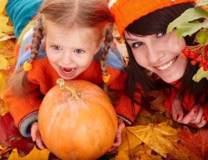 Happy family with child on autumn orange leaf