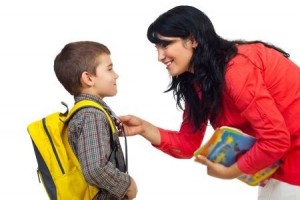 Mother having an conversation with her son before going to school and standing face to face isolated on white background