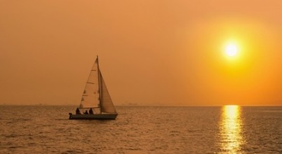 Sailing boat in the sea at sunset
