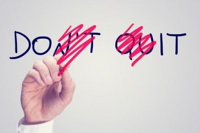 conceptual image with a man scrubbing through letters in the words Dont Quit