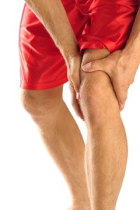 Injured athlete in pain clutches his knee