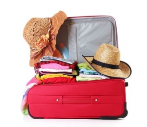 Open red suitcase with clothing isolated on a white