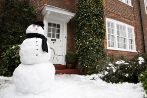 Snowman at the front door of a house in winter