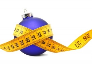 Tape measure around a bauble concept symbolizing Christmas weight gain from eating too much food