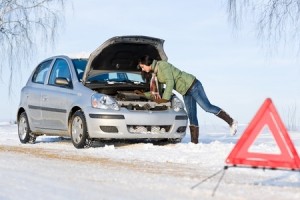 Winter car breakdown - woman try to repair motor
