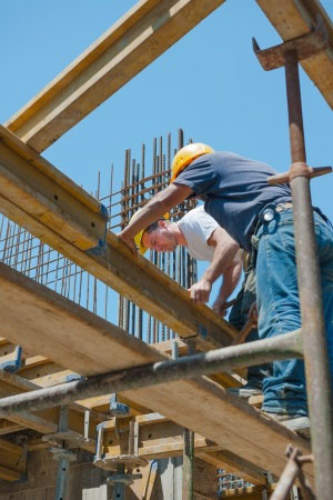 Authentic construction workers placing slab formwork beams in construction site