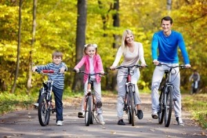 Family on bikes in the park in autumn