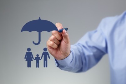 Businessman hand drawing an umbrella above a family concept for protection