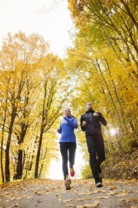 Young running couple jogging in autumn nature