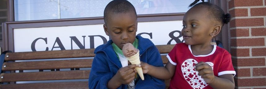 Boy and girl sharing ice cream cone