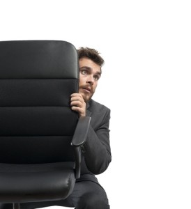 Concept of fear of a businessman behind a chair