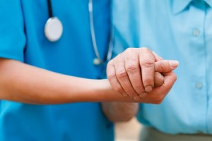 Doctor holding elderly patient's hands with care