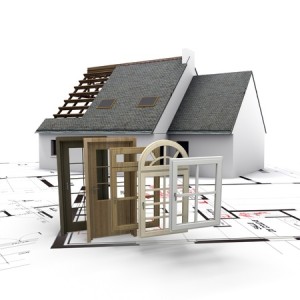 A house under construction, with blueprints and a selection of windows and doors