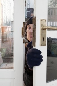 Breaking and entering home or house, Burglar with screwdriver force open door. Thief attempting to breach security