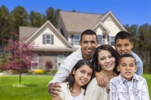 Happy Hispanic Family Portrait in Front of Beautiful House