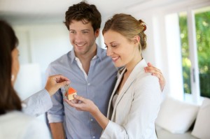 14102934 - happy young couple getting keys of their new home