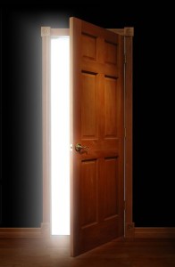 Door opening with bright light illuminating a dark space