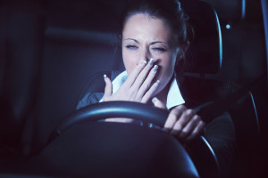 36877123 - distracted exhausted tired woman driving a car late at night.