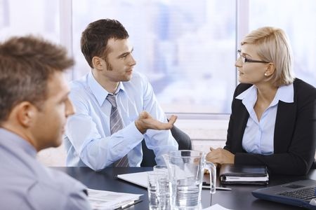Businessman talking to businesswoman at business meeting in office