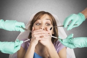 39234929 - girl frightened by dentists covers her mouth