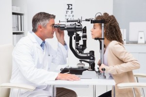 38131158 - woman doing eye test with optometrist in medical office