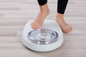 51726261 - low section of person standing on weighing scale