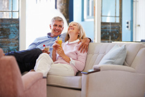 41402455 - mature couple at home relaxing in lounge with cold drinks