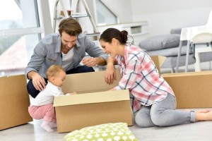 47872766 - young family unpacking boxes in new home