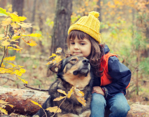 45763876 - sad little girl walking with dog in the fores