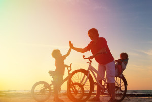 42949607 - biker family silhouette, father with two kids on bikes