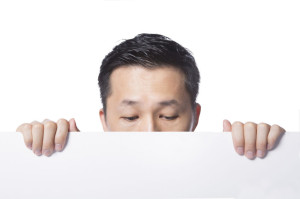 65885550 - man hiding behind the white paper, blank board for edited.