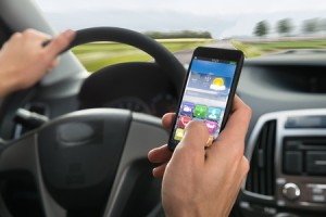 44311839 - close-up of a person's hand using cellphone while driving a car