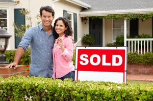 11217831 - hispanic couple outside home with sold sign