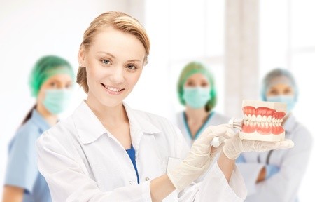 20613496 - attractive female doctor with toothbrush and jaws in hospital