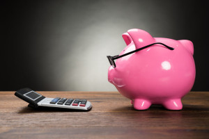 41236520 - piggybank with eyeglasses and calculator on wooden table