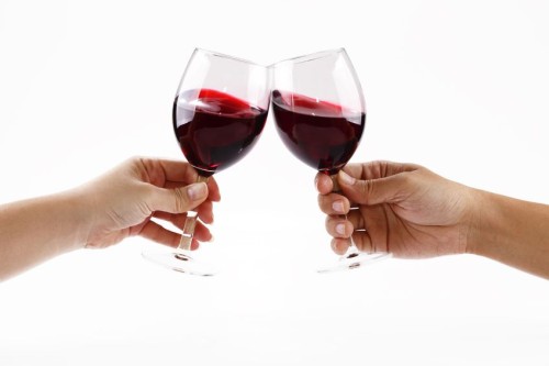 6335388 - two people toasting with wine glasses filled with red wine