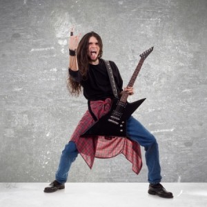 17624930 - long haired guitarist is playing and making a rock hand gesture