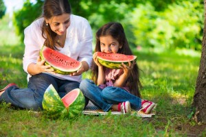 20996372 - happy hispanic family eating watermelon at park