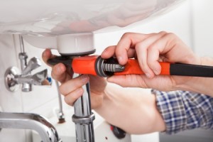 21234963 - portrait of male plumber fixing a sink in bathroom