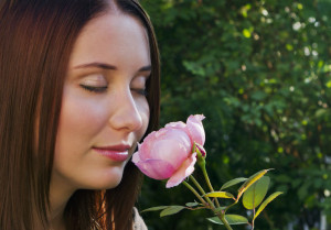 22249121 - closeup of beautiful young brunette girl smelling roses
