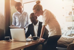 47170936 - group of entrepreneurs working using a laptop and holding a document