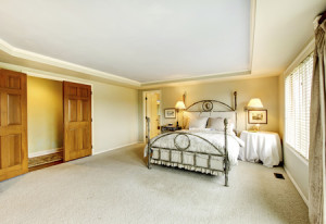 64353306 - beautiful golden bedroom with open wooden doors and beige carpet.