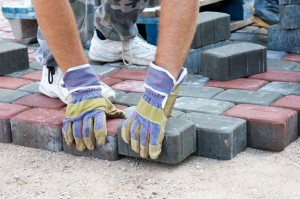 11586319 - a worker made a sidewalk from bricks