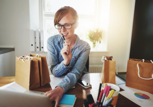 44245897 - young woman working at home on her laptop, small office